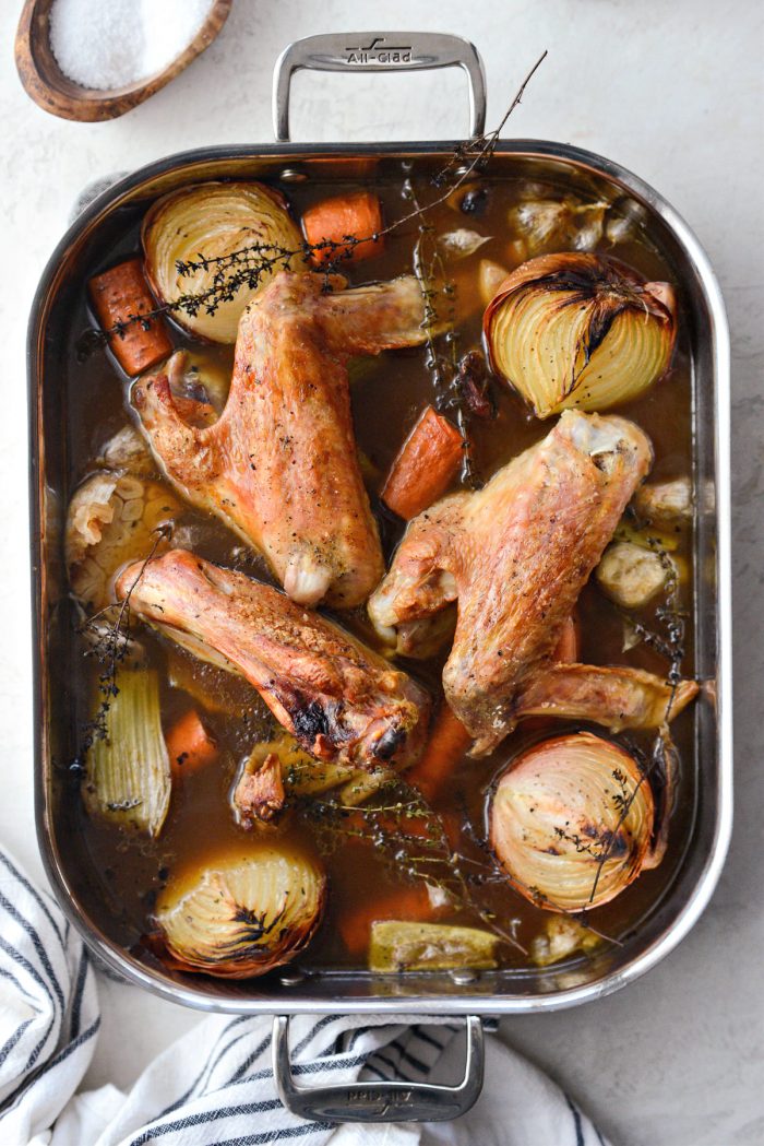 reduced broth in roasting pan with turkey, vegetables and thyme.