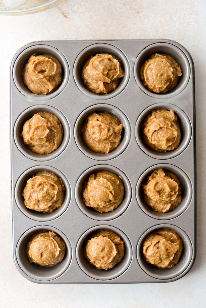 pumpkin pie batter divided among muffin tin.