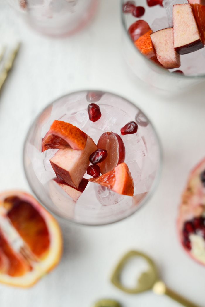 ice and some fruit to glasses.