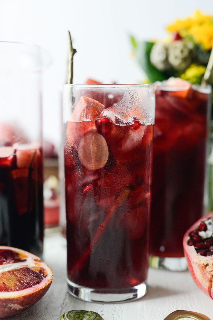 partially full glass of pomegranate sparkling apple cider sangria.