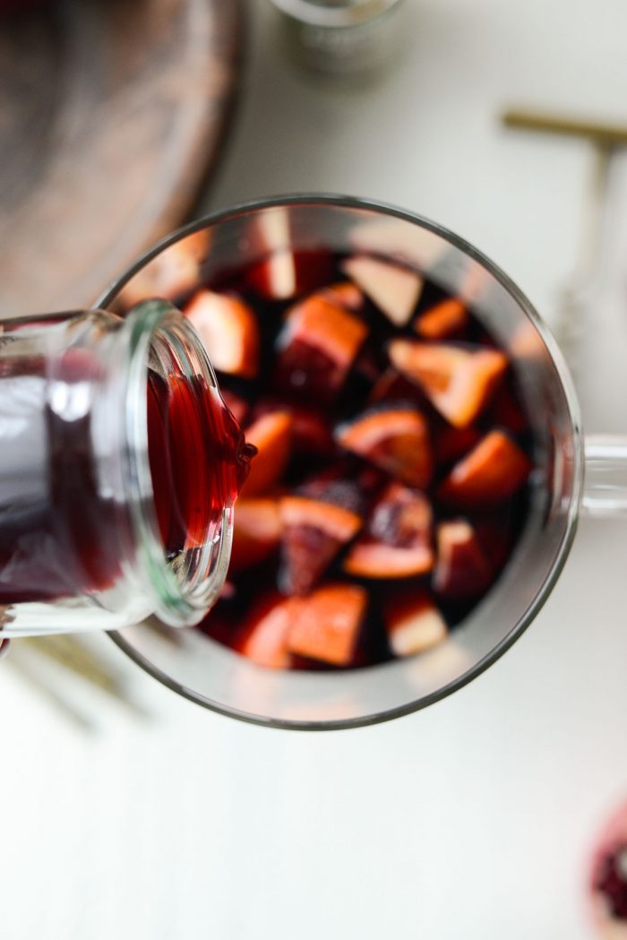 then pouring pomegranate juice into pitcher.