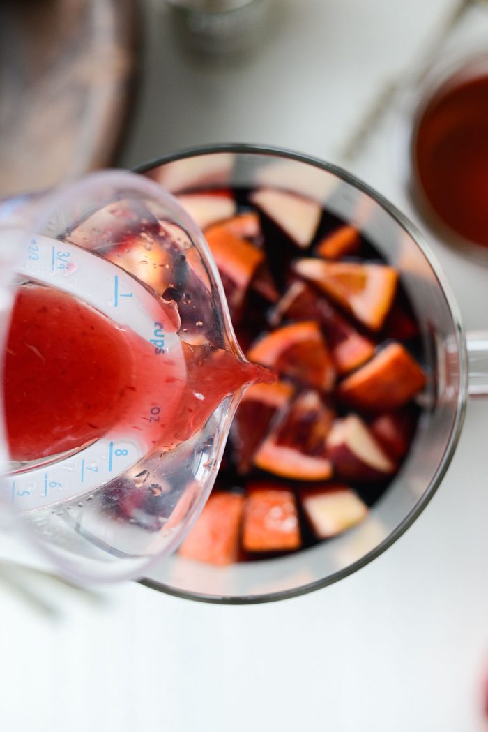 pouring blood orange juice into pitcher.