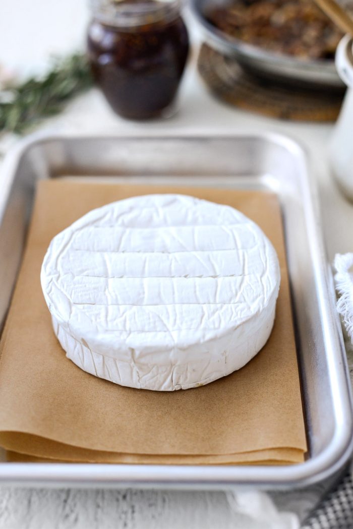 top of brie is scored and then placed on parchment paper