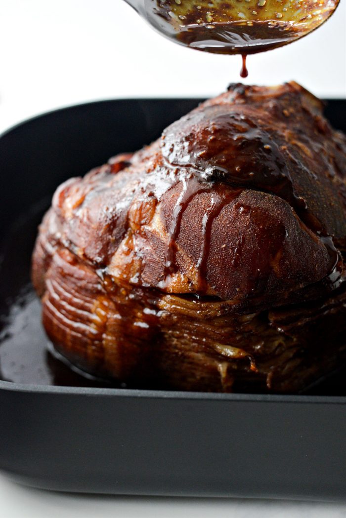 spoon glaze from roasting pan over ham.