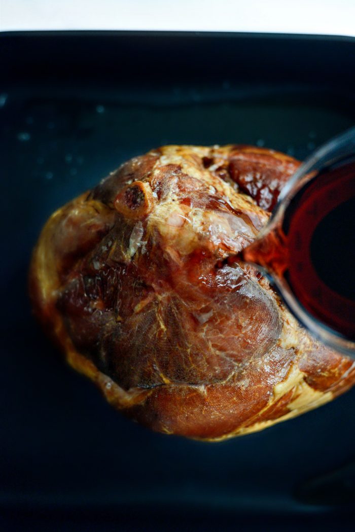 pouring juice and bourbon over ham