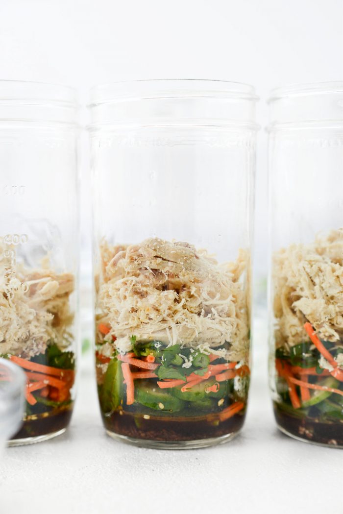 mason jar with cilantro, green onion and cooked shredded chicken added.