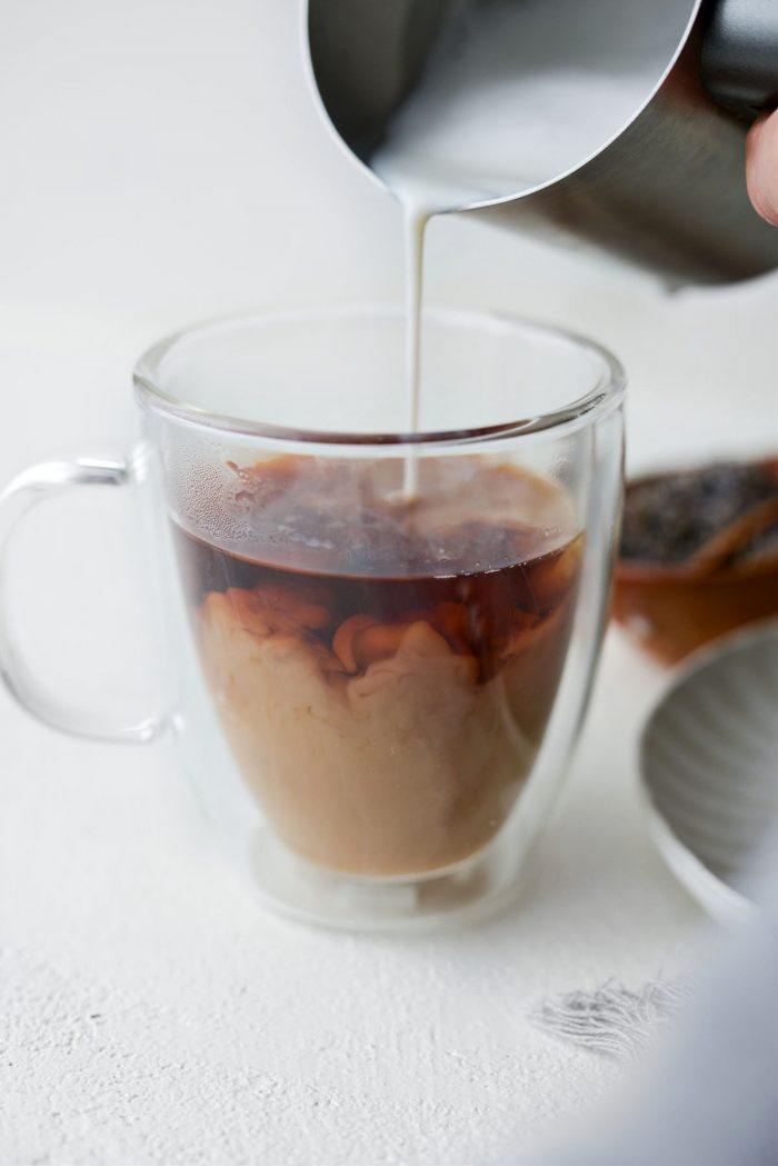 pour frothed milk into tea