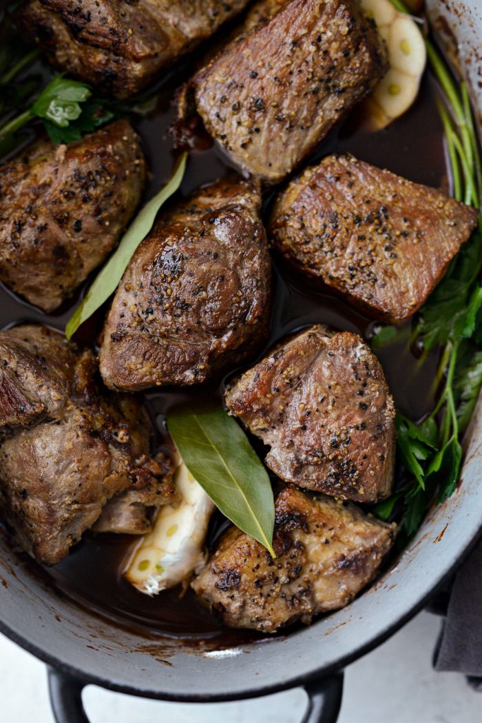 seared pork and bay leaves added to pot with vegetables