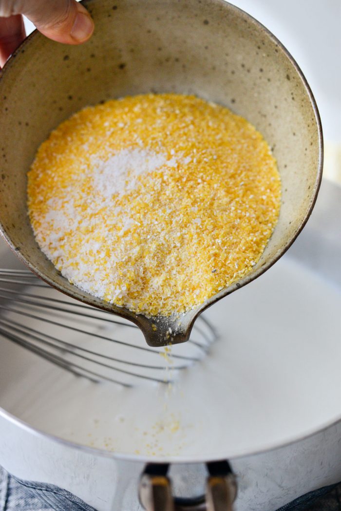 pour in corn grits and kosher salt to simmering milk