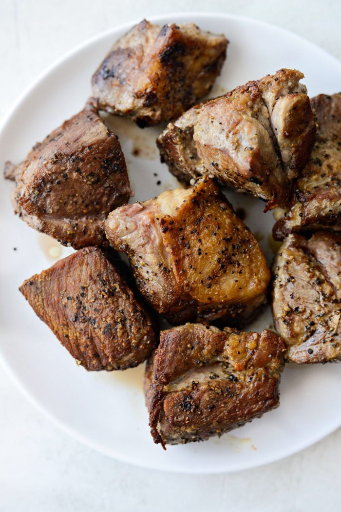 seared pork on a white plate.