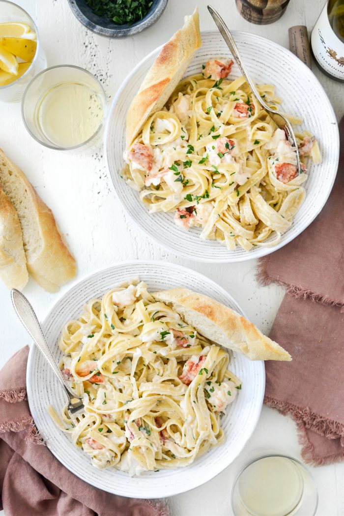 two bowls of Garlicky Lobster Fettuccine Alfredo with bread.