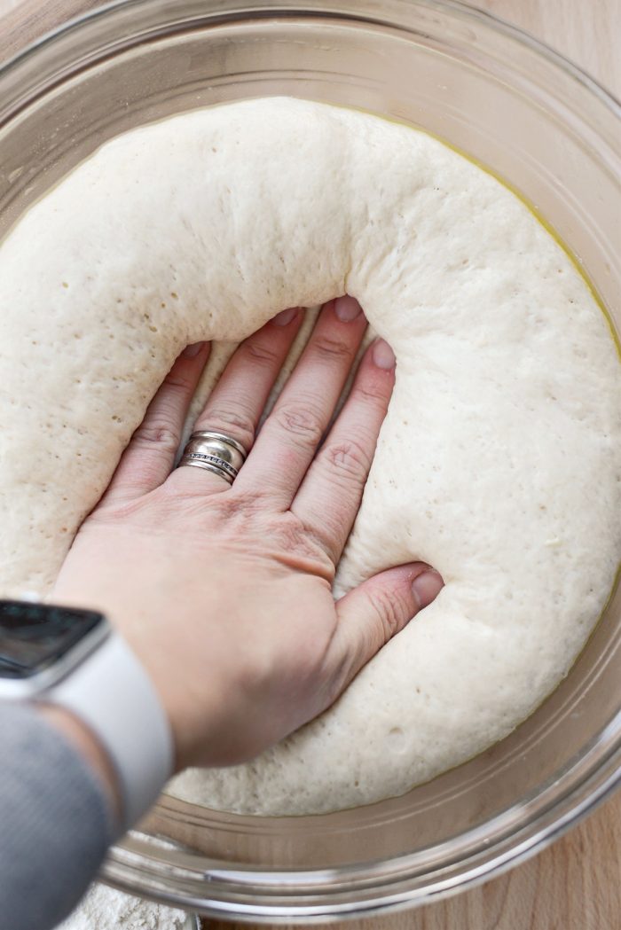 press on pizza dough to deflate