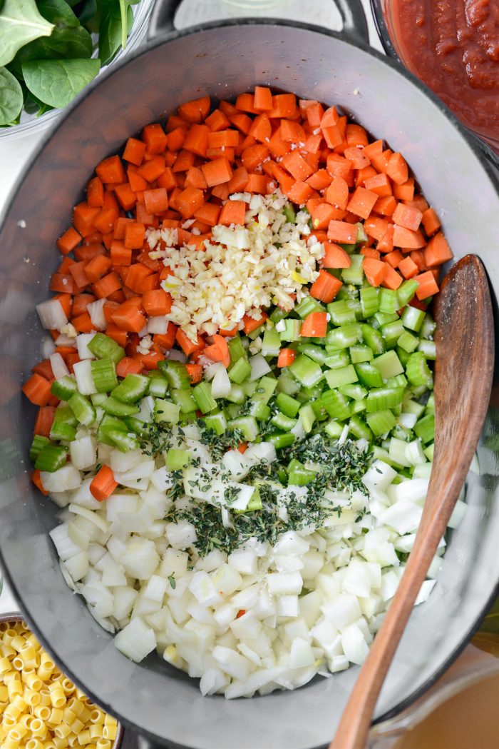 vegetables and herbs added to pot