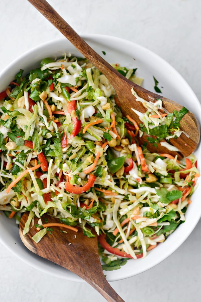 Thai Cabbage Salad in white bowl with wooden servers