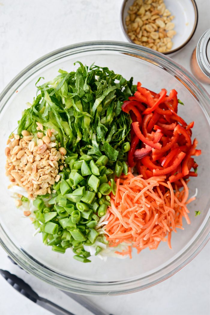 cabbage, romaine, red pepper, carrots and peanuts in bowl.