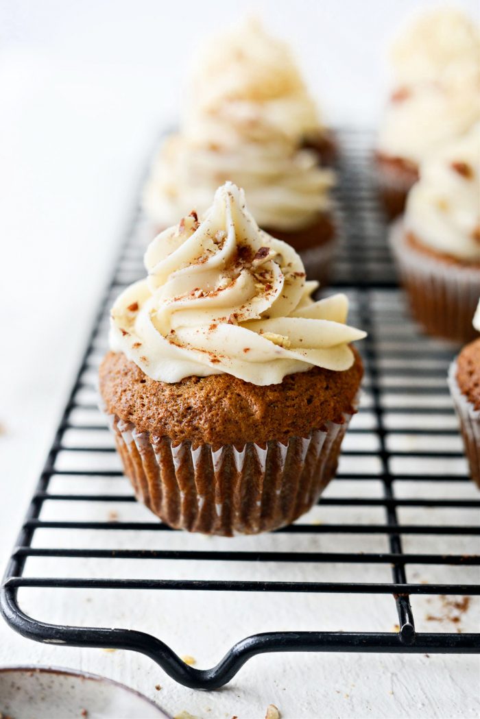 Garnish Carrot Cake Cupcakes with ground cinnamon and chopped pecans.