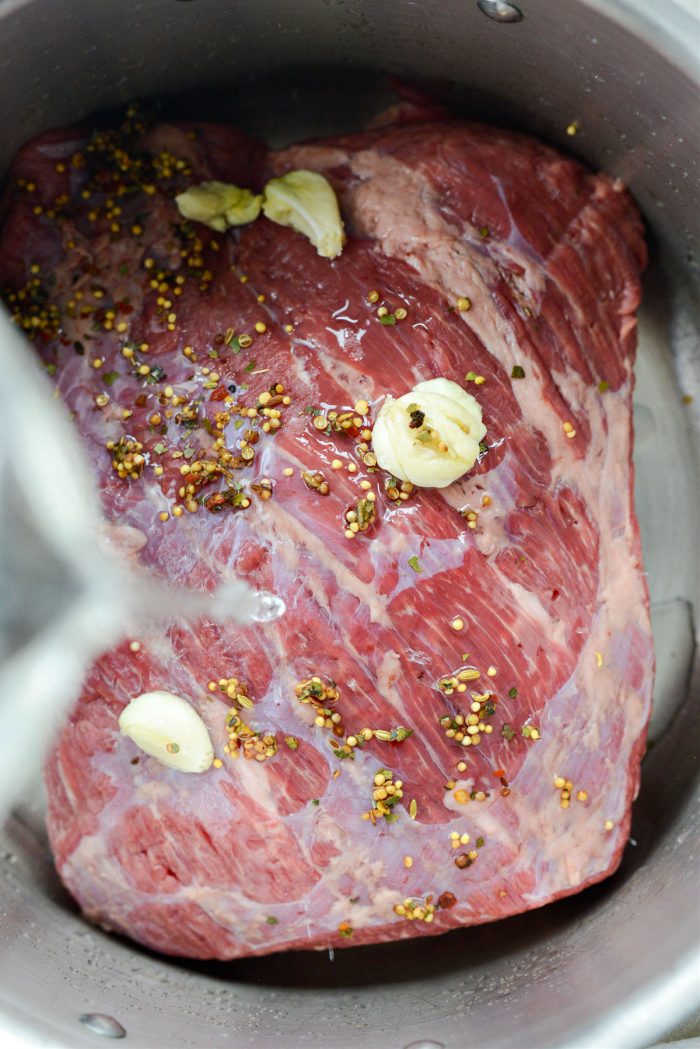 corned beef, seasoning, garlic and water in a pot.