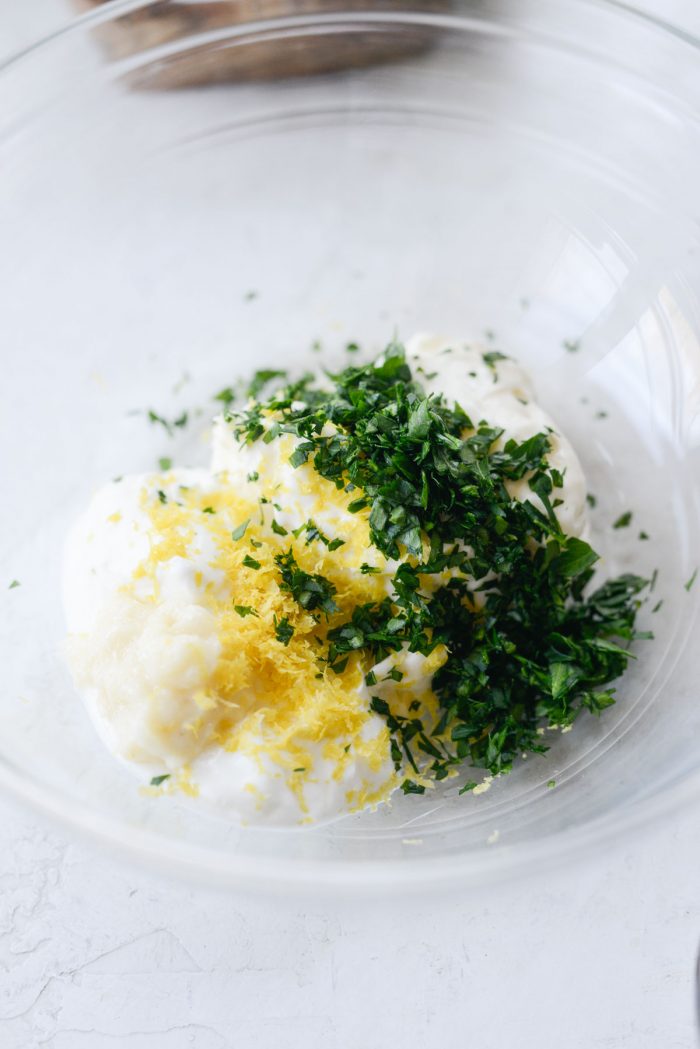 mayo, greek yogurt, garlic paste, lemon zest and parsley in a bowl