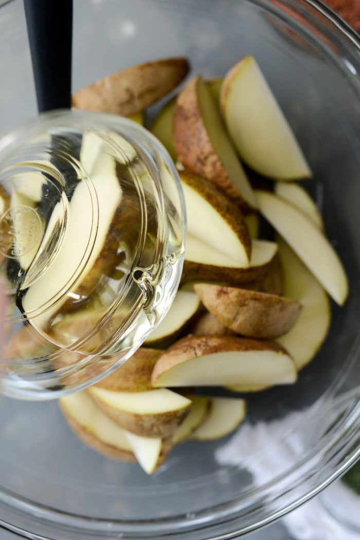 potato wedges and oil in a bowl