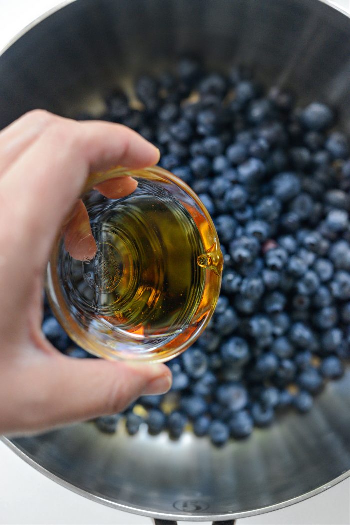 adding maple syrup to blueberries