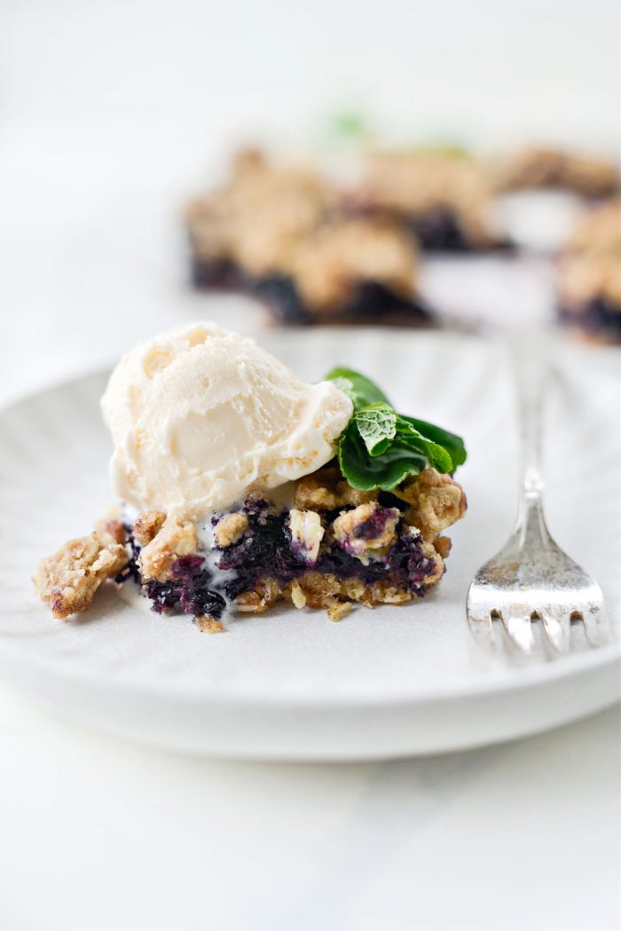 Blueberry Oatmeal Crumble Pie Bars with scoop of vanilla ice cream