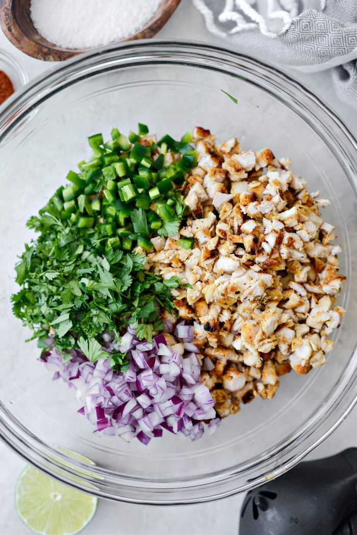 chopped grilled chicken, onion, cilantro and jalapeno in bowl.