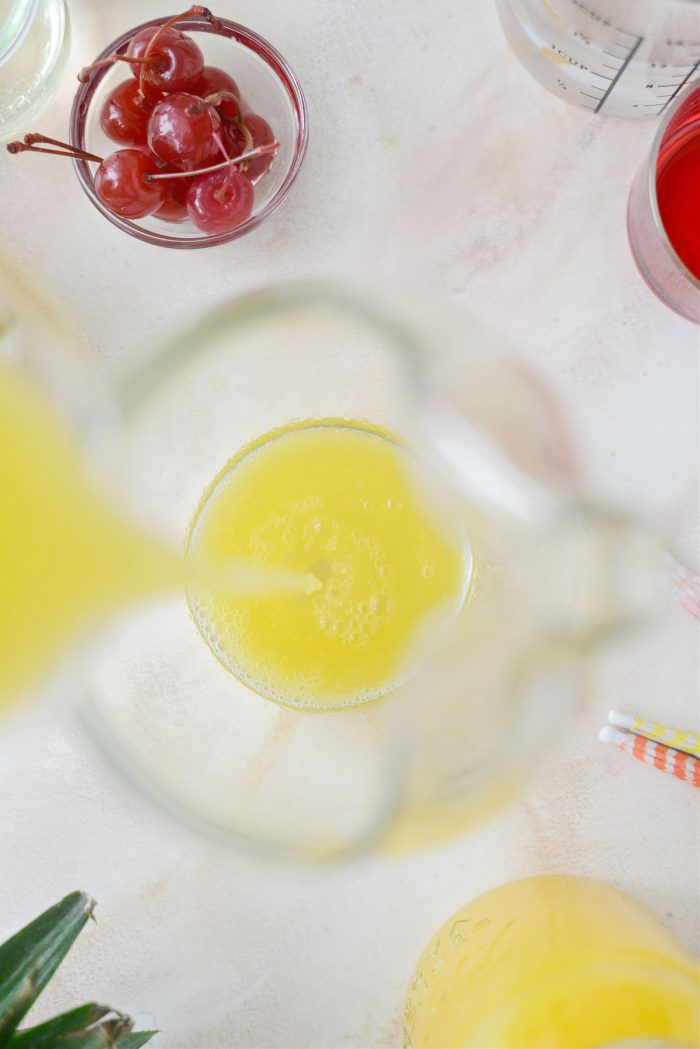 pouring pineapple juice into pitcher