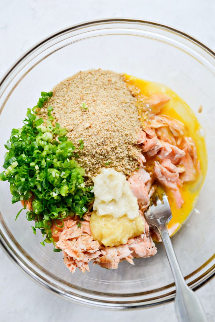 flaked salmon, chopped green onion, garlic, ginger, egg, coconut aminos and toasted sesame oil in bowl.