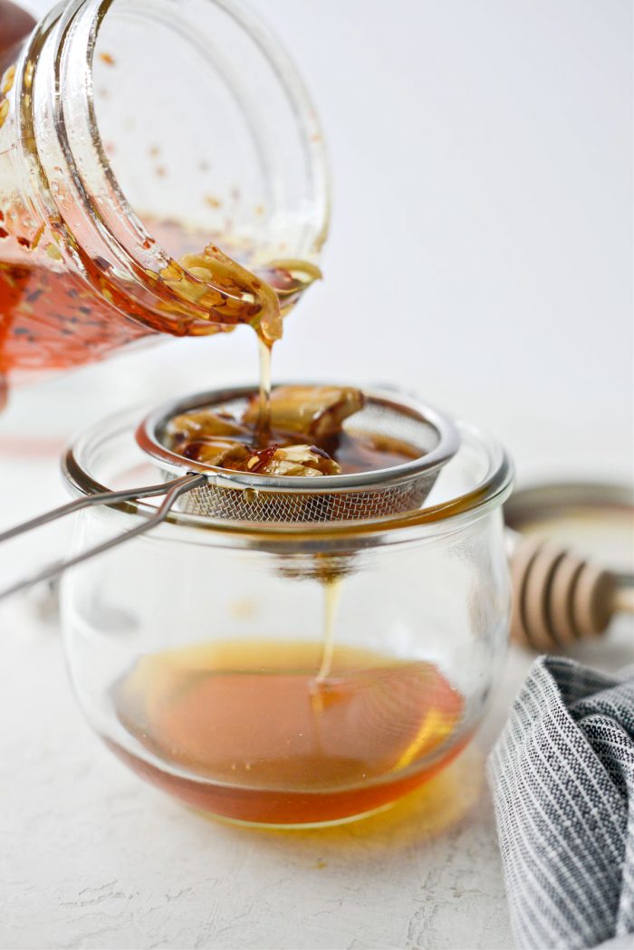 pour honey through strainer