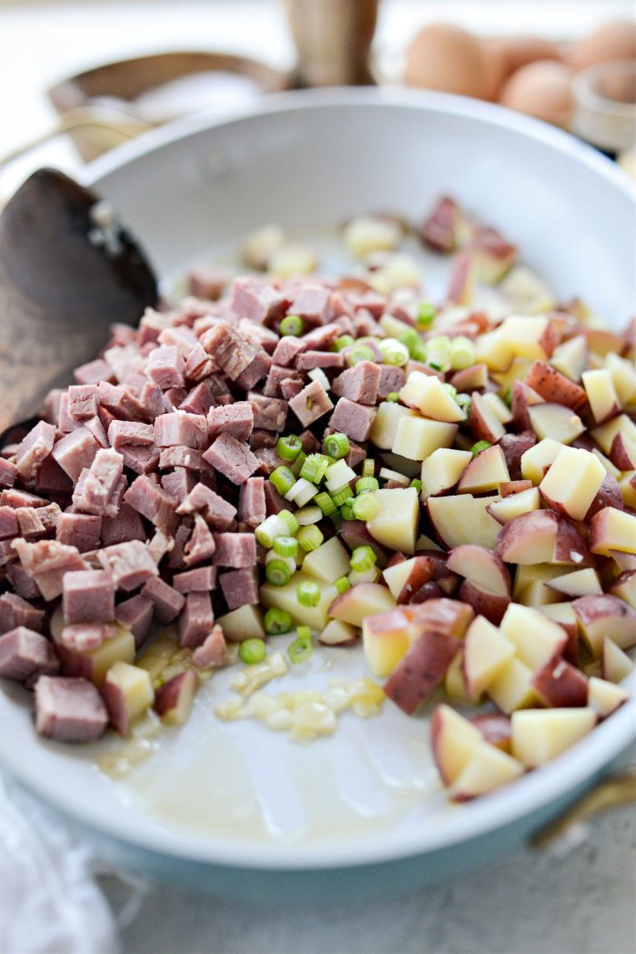 add potatoes, corned beef and the light parts of 2 green onions
