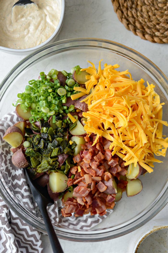 quartered potatoes, bacon, poblanos, green onion and cheddar in a bowl