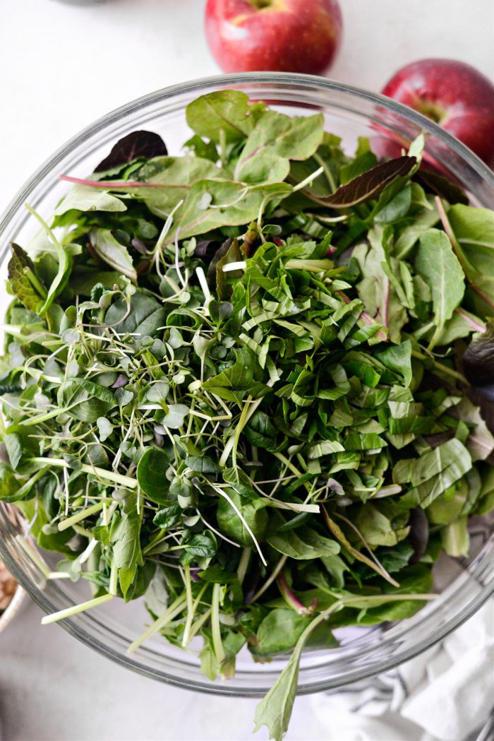 mixed salad greens, micro greens and chopped basil in bowl