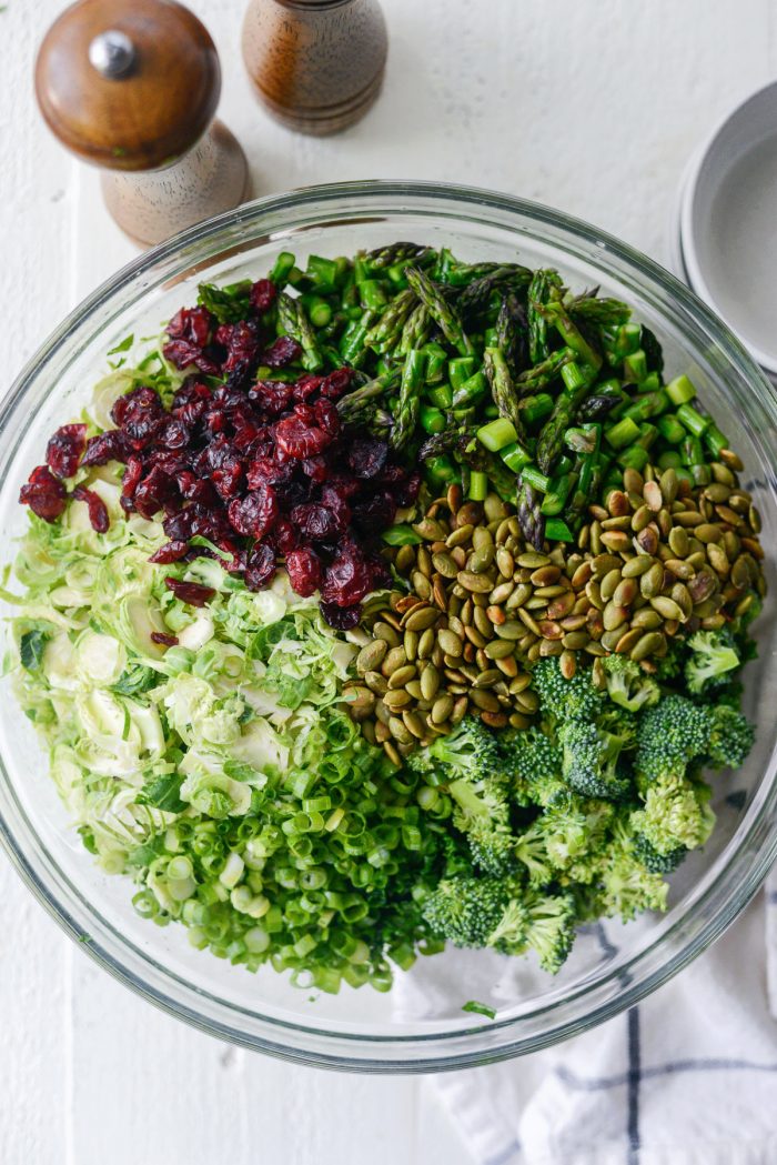 add shredded brussels, asparagus, broccoli, green onion, craisins and toasted pepitas