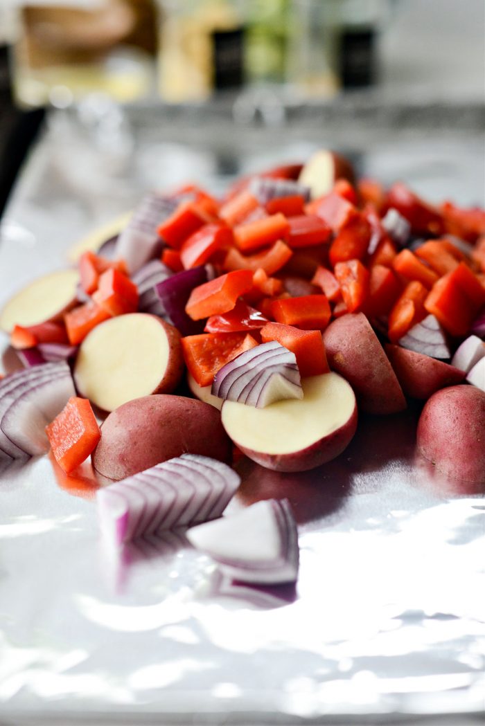 potatoes, onions and peppers on lined sheet pan