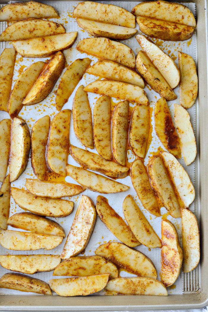 wedges of potatoes arranged in an even layer on prepared pan.