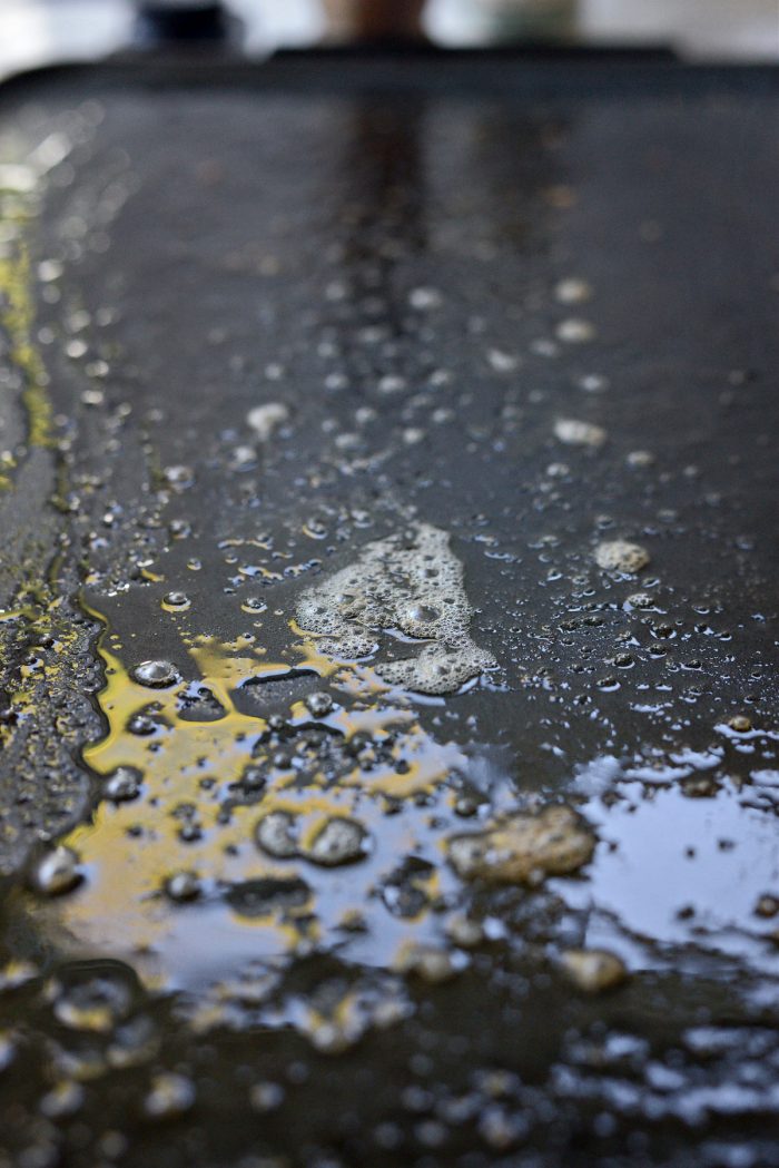 butter and oil on griddle for steak