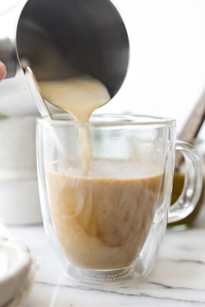 pour frothed milk into mug