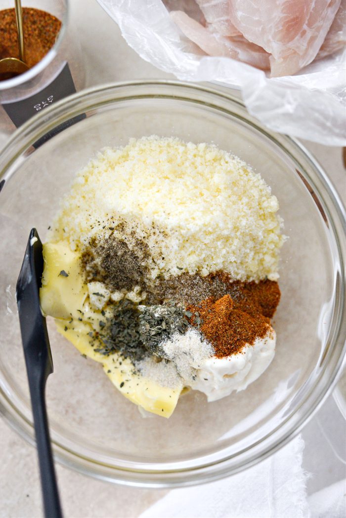 Agregue mantequilla, mayonesa, queso parmesano, hierbas secas y especias en un tazón.