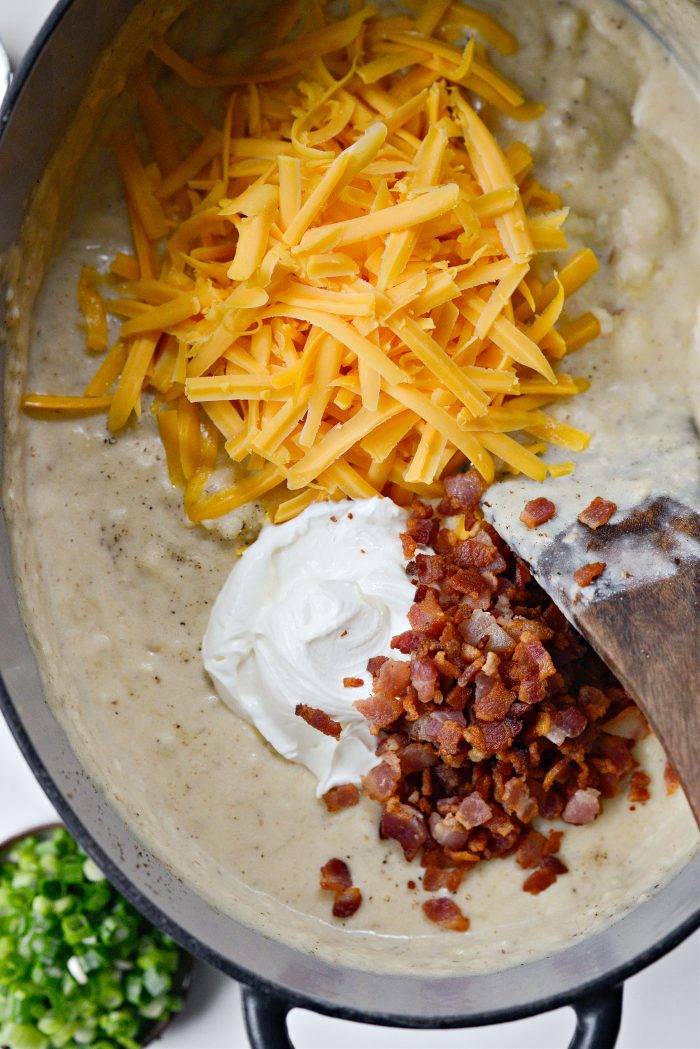 Add 3/4 of the cheese and bacon and 1/2 cup sour cream. The reserved cheese and bacon is for serving.