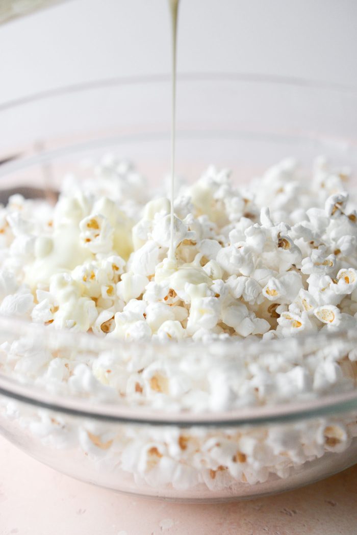 pour melted white chocolate over popped popcorn