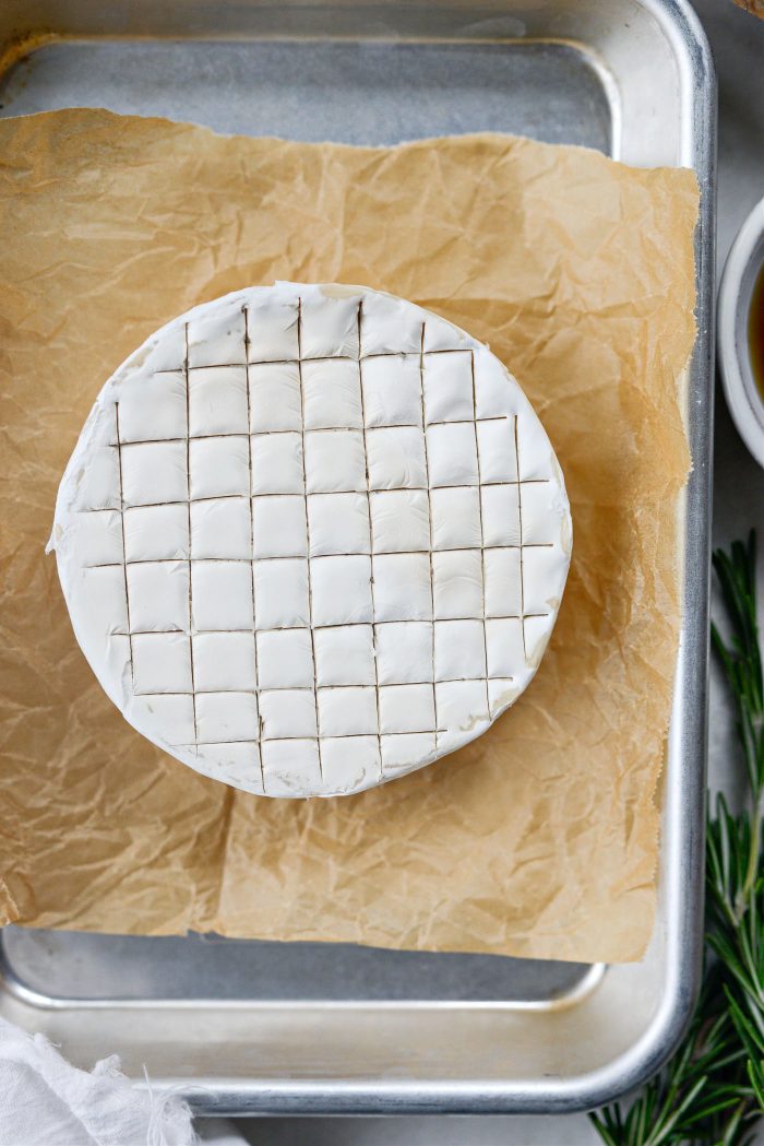 score brie and place on parchment in pan