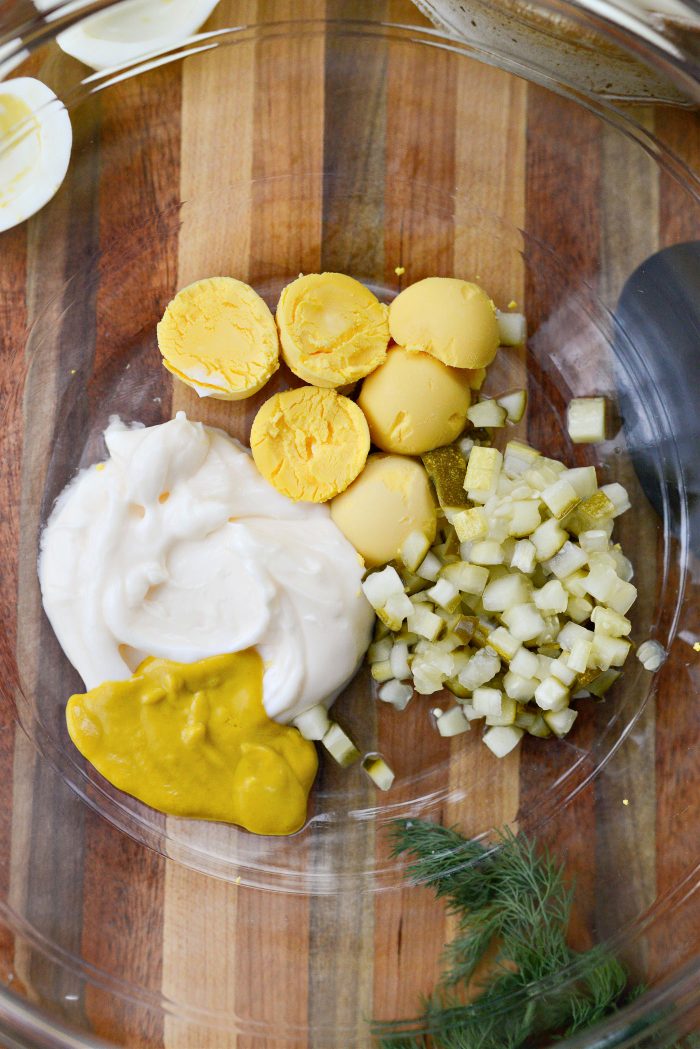 add a few egg yolks, pickles, pickle juice, mayo and mustard to a bowl