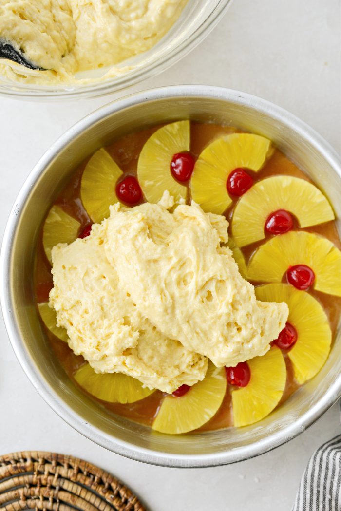 spoon cake batter over top of pineapples and cherries