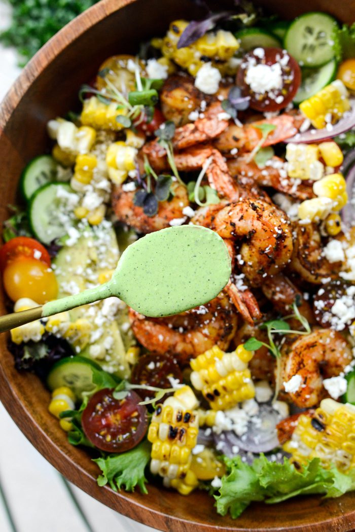 Drizzle salad with dressing