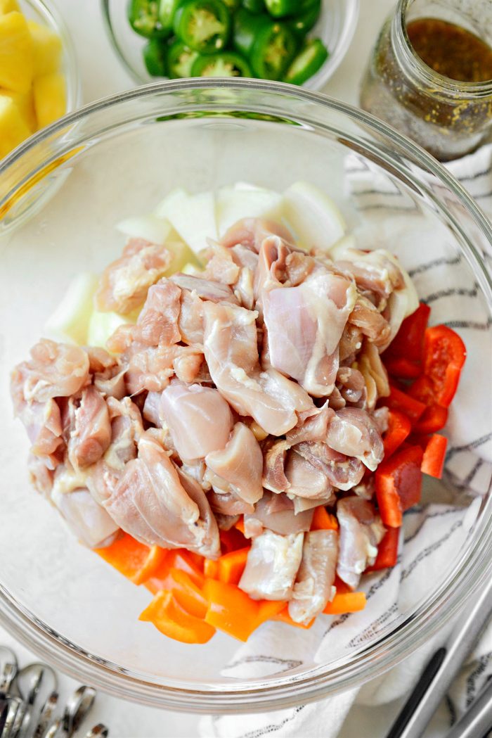 peppers, onions and diced chicken thighs in bowl