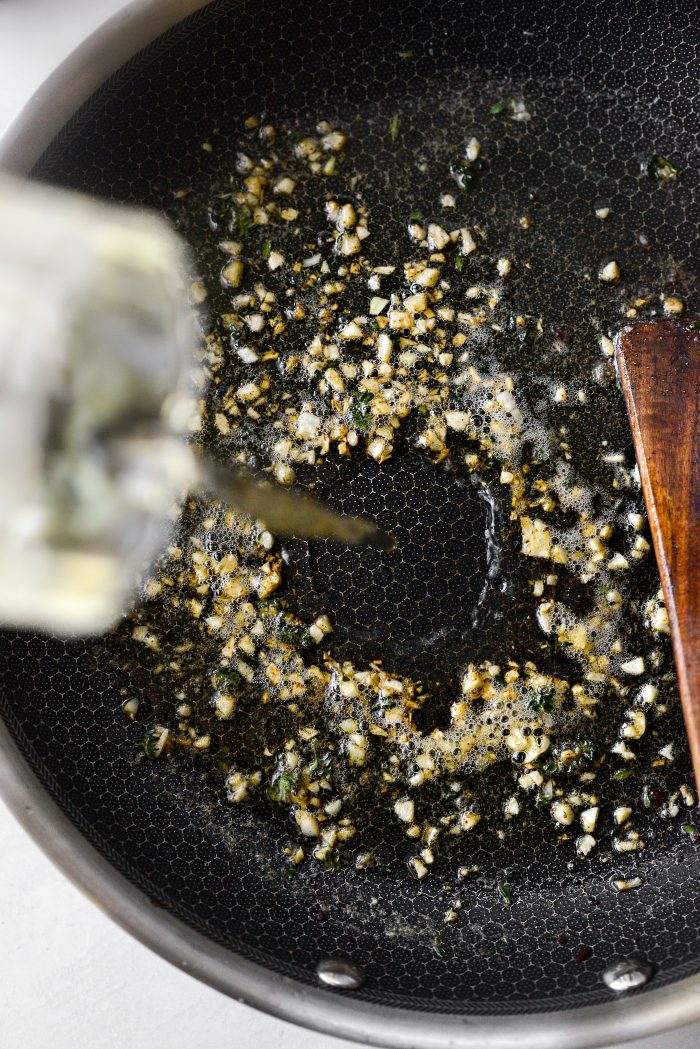 pour wine into sautéed garlic and thyme