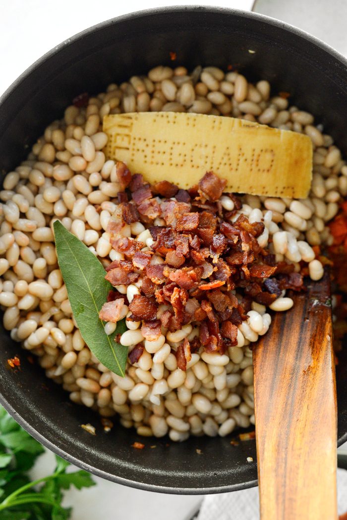 add beans, bacon, parmesan cheese rind and bay leaf