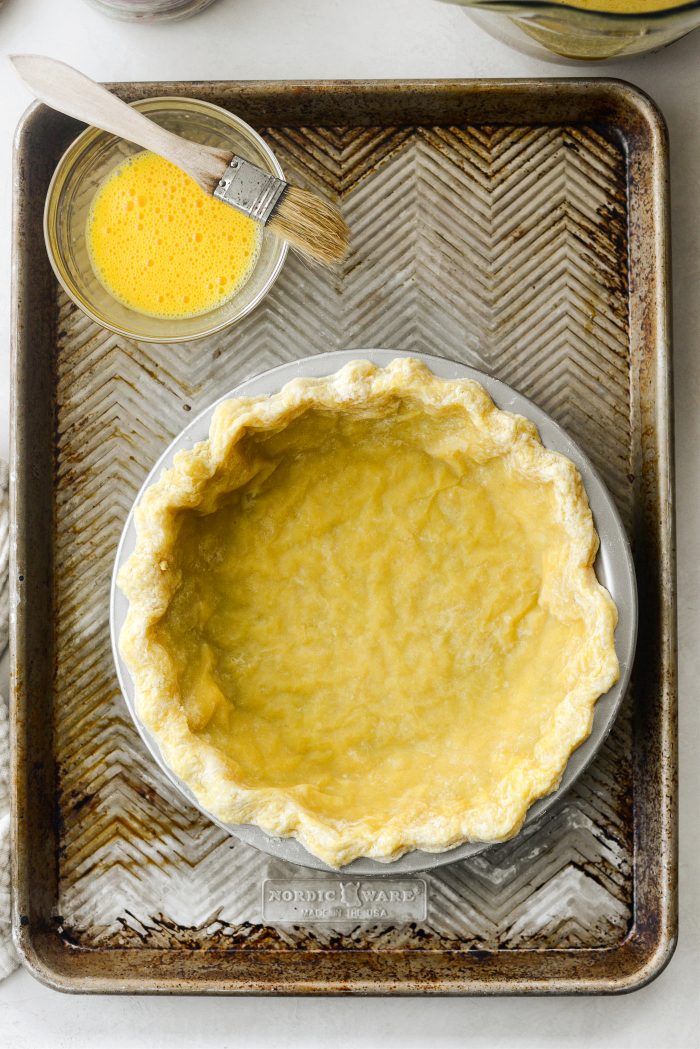 place blind baked pie crust on baking sheet and make egg wash