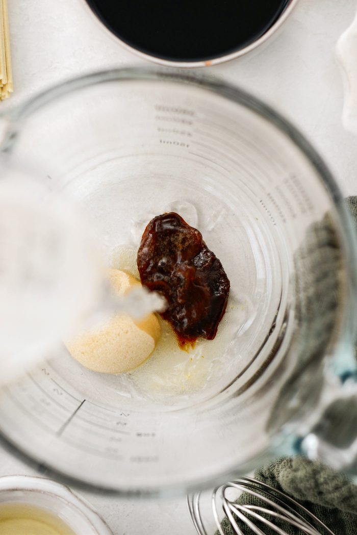 Add brown sugar, vegetable bouillon, and hot water to a bowl.