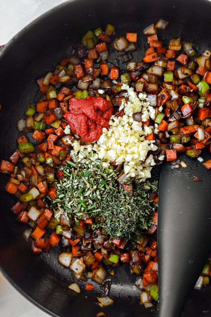 to sautéed veggies add tomato paste, garlic, rosemary and thyme